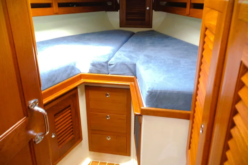 Slide: The Image of Cozy cabin interior of 2009 Pacific Seacraft 34 sailboat with wooden finish and blue cushions. - 6