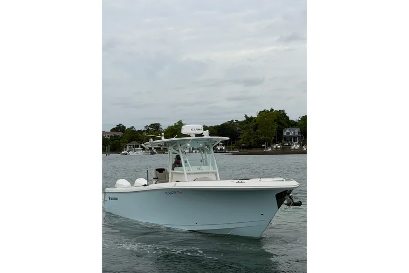 Slide: The Image of 2021 Sailfish 290 CC boat on calm water near shoreline. - 10