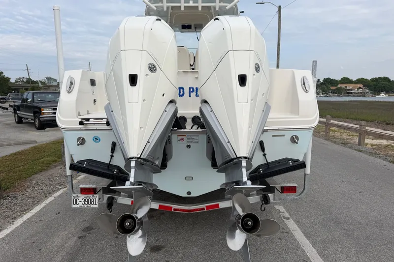 Slide: The Image of 2021 Sailfish 290 CC boat with dual outboard engines on a trailer. - 13