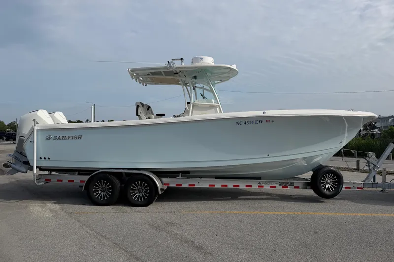 Slide: The Image of 2021 Sailfish 290 CC boat on trailer, side view, parked outdoors. - 14