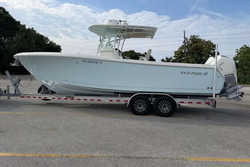 Slide: The Image of 2021 Sailfish 290 CC boat on trailer in parking lot, side view. - 19
