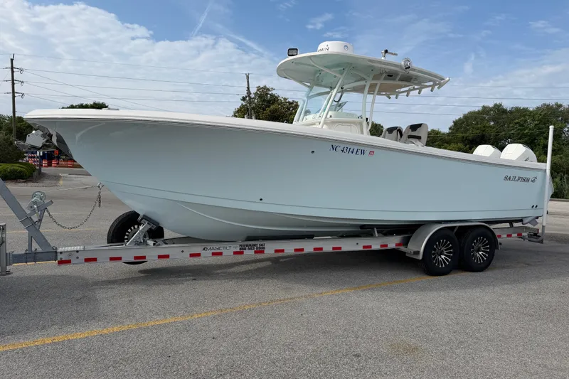 Slide: The Image of 2021 Sailfish 290 CC boat on trailer, parked outdoors under a clear sky. - 20