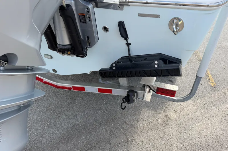 Slide: The Image of Rear view of a 2021 Sailfish 290 CC boat on a trailer, showing motor and trim tab. - 21