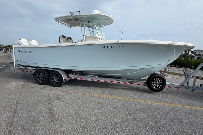 Slide: The Image of 2021 Sailfish 290 CC boat on trailer, parked on a paved surface. - 22