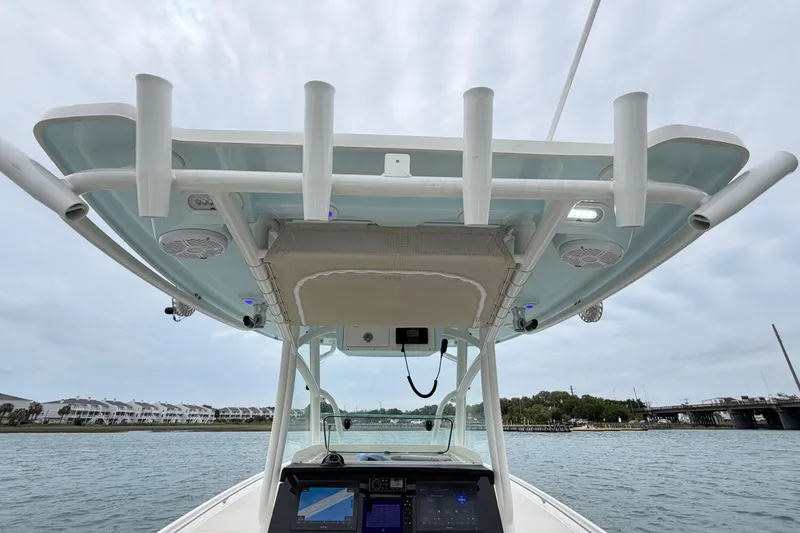 Slide: The Image of 2021 Sailfish 290 CC boat helm with T-top and rod holders on the water. - 40