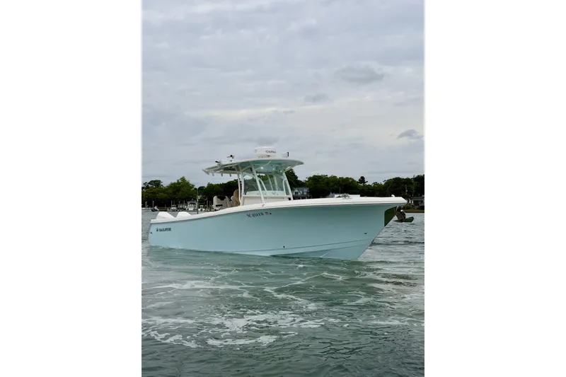 Slide: The Image of 2021 Sailfish 290 CC boat cruising on a calm, cloudy day. - 7