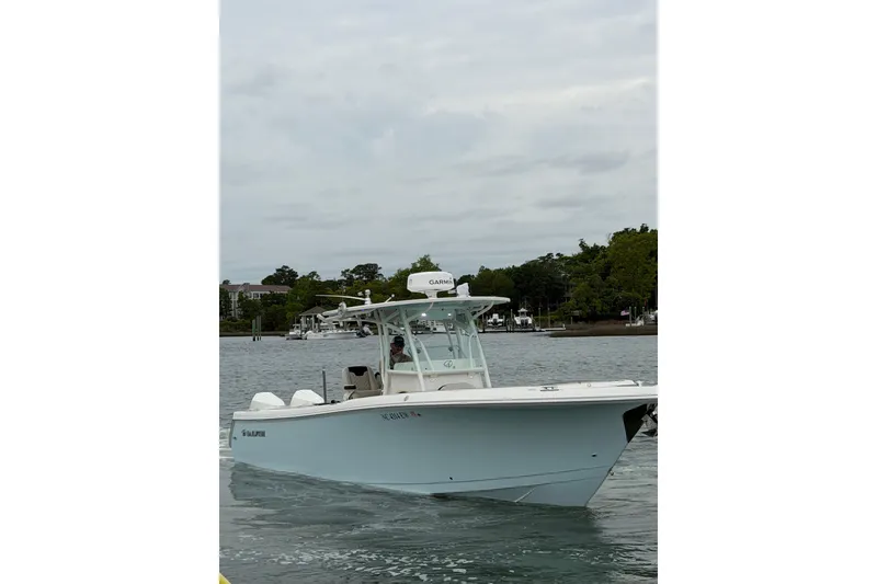 Slide: The Image of 2021 Sailfish 290 CC boat cruising on a calm waterway. - 9