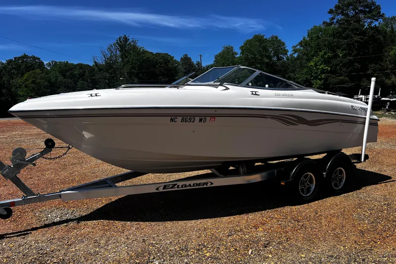 The Image of 1998 Four Winns 220 Horizon boat on trailer, parked outdoors under clear sky. - 1