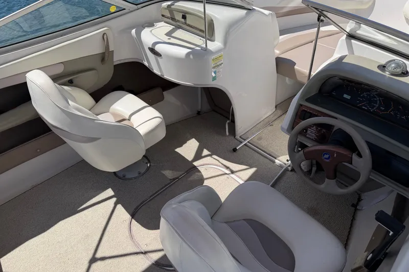 Slide: The Image of 1998 Four Winns 220 Horizon boat interior with steering wheel and seating. - 12