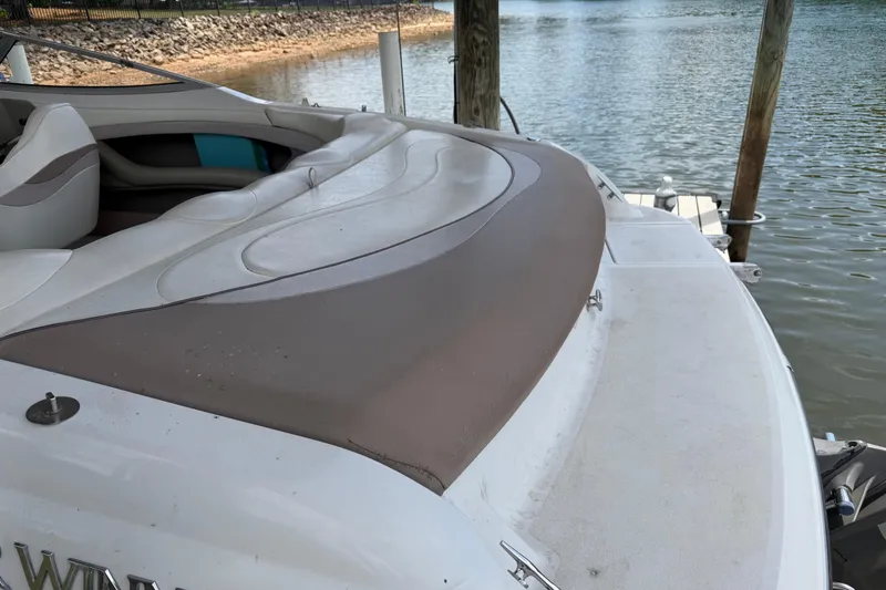 Slide: The Image of 1998 Four Winns 220 Horizon boat with cushioned seating, docked by a calm lake. - 17
