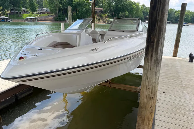 Slide: The Image of 1998 Four Winns 220 Horizon boat docked on a serene lake with lush greenery. - 20