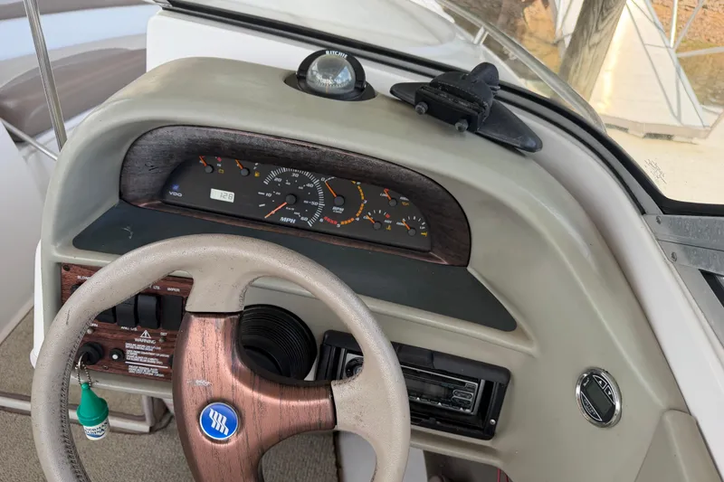 Slide: The Image of Steering console of a 1998 Four Winns 220 Horizon boat with gauges and controls. - 24