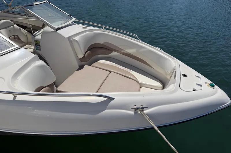 Slide: The Image of 1998 Four Winns 220 Horizon boat with spacious seating, docked on calm water. - 8