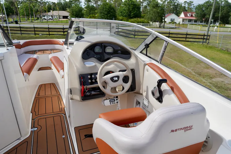 Slide: The Image of Interior of a 2001 Stingray 240 LS boat with tan and white seating. - 13