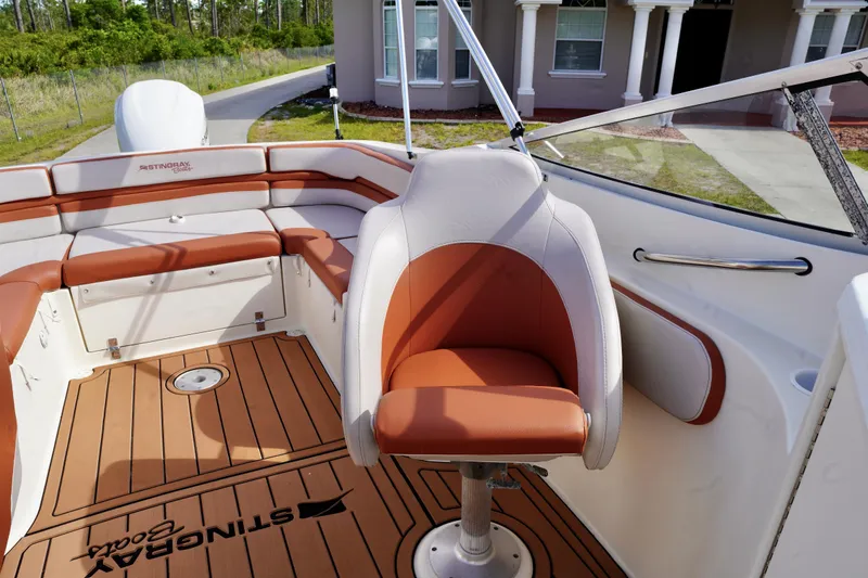 Slide: The Image of Interior of a 2001 Stingray 240 LS boat with tan seating and wood-style flooring. - 18