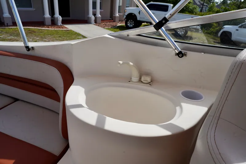 Slide: The Image of 2001 Stingray 240 LS boat interior with sink and seating area. - 19