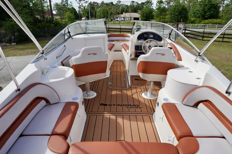 Slide: The Image of Interior of a 2001 Stingray 240 LS boat with tan and white seating. - 22