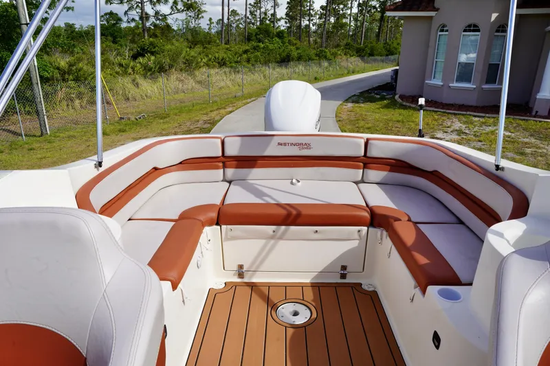 Slide: The Image of Interior of a 2001 Stingray 240 LS boat with cushioned seating and wood-style flooring. - 24