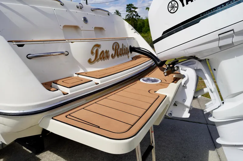Slide: The Image of 2001 Stingray 240 LS boat with "Tax Relief" name, featuring a swim platform and outboard motor. - 26