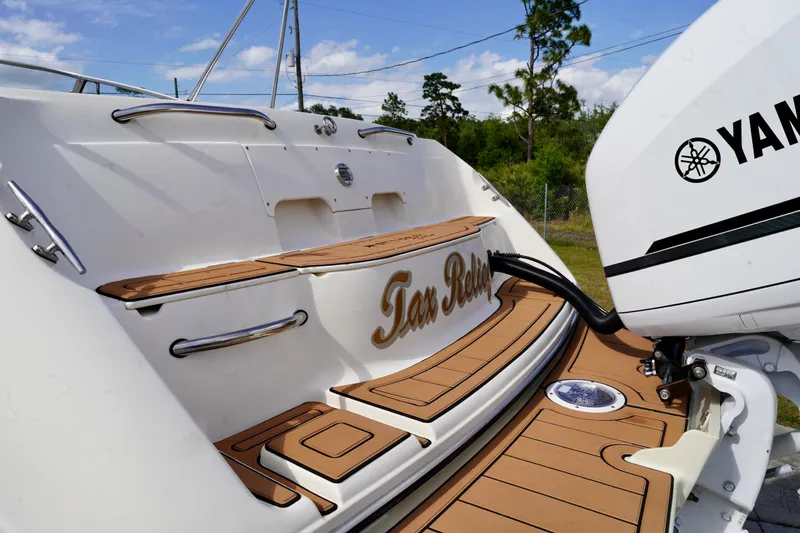 Slide: The Image of 2001 Stingray 240 LS boat with Yamaha engine, featuring teak-style decking and "Tax Relief" name. - 27