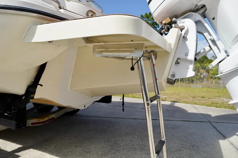 Slide: The Image of 2001 Stingray 240 LS boat with extended swim platform and ladder on concrete surface. - 28