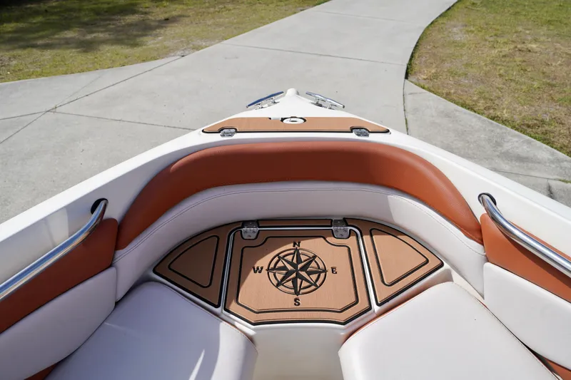 Slide: The Image of 2001 Stingray 240 LS boat interior with compass design, featuring tan and white seating. - 5