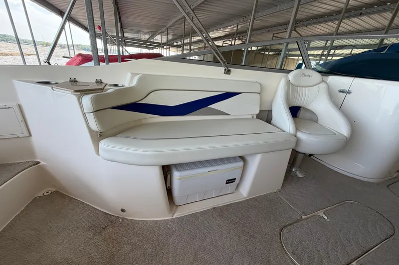 Slide: The Image of 2005 Rinker 282 Captiva Bowrider interior with white seating and storage compartment. - 10