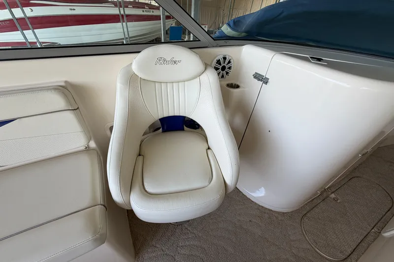 Slide: The Image of 2005 Rinker 282 Captiva Bowrider interior with white seating and speaker detail. - 11