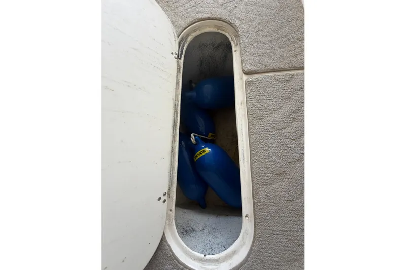 Slide: The Image of Storage compartment with blue fenders on a 2005 Rinker 282 Captiva Bowrider boat. - 22