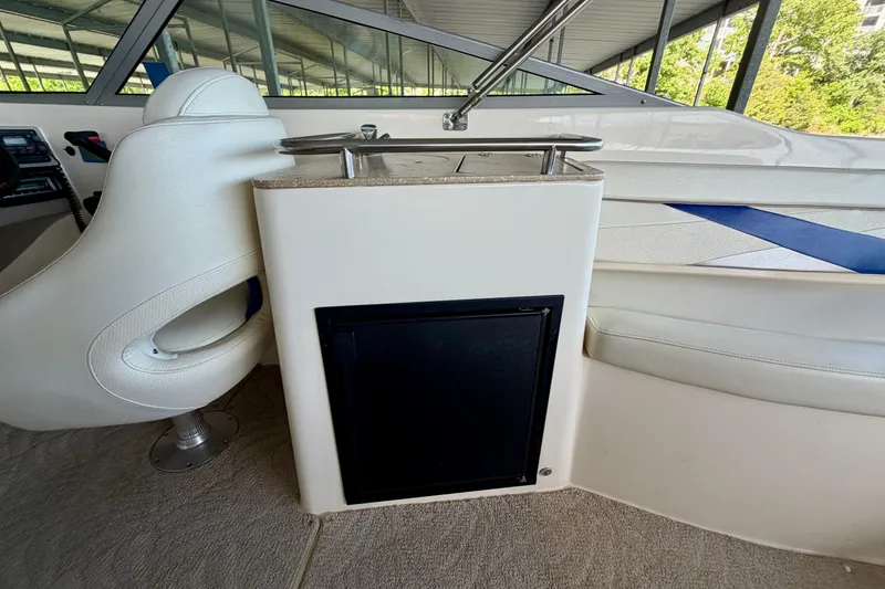 Slide: The Image of 2005 Rinker 282 Captiva Bowrider interior with white seating and compact kitchenette. - 8