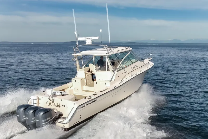 Slide: The Image of 2006 Grady-White Express 360 boat cruising on open water, featuring triple Yamaha engines. - 11