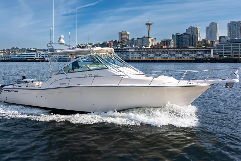 Slide: The Image of 2006 Grady-White Express 360 boat cruising near urban skyline, clear blue sky. - 2