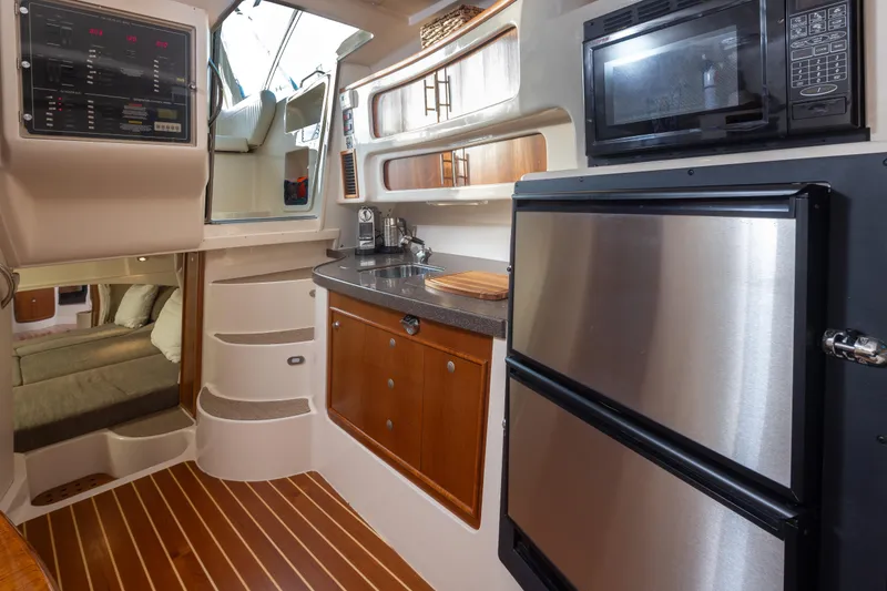 Slide: The Image of 2006 Grady-White Express 360 interior with kitchenette, microwave, and stainless steel fridge. - 25