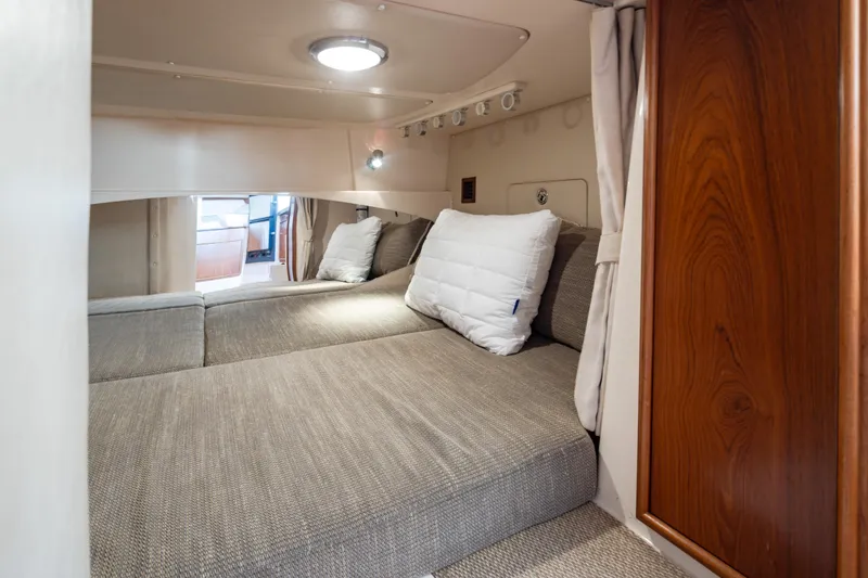 Slide: The Image of Interior cabin of 2006 Grady-White Express 360 boat, featuring cozy bedding and wooden accents. - 29