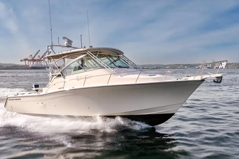 Slide: The Image of 2006 Grady-White Express 360 boat cruising on open water, with industrial background. - 8