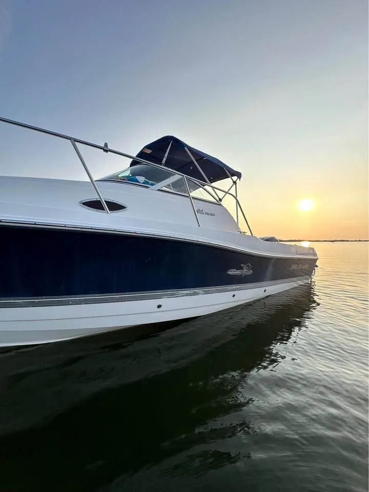 Slide: The Image of 2004 Wellcraft WALK AROUND boat on water at sunset. - 2