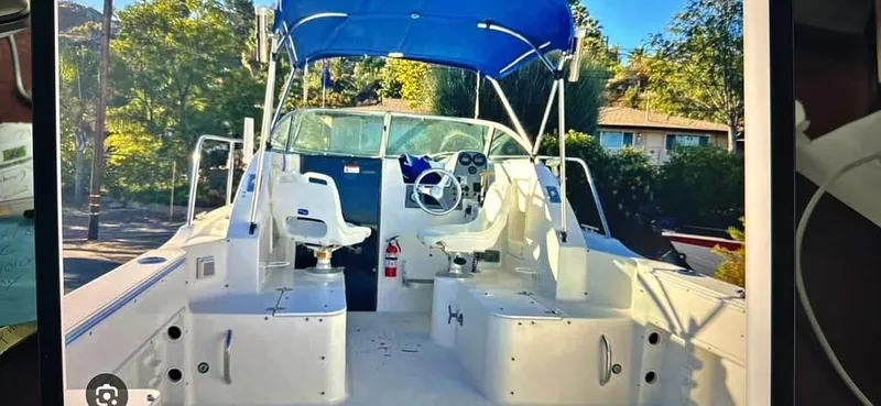 Slide: The Image of 2004 Wellcraft WALK AROUND boat with blue canopy and helm station. - 6