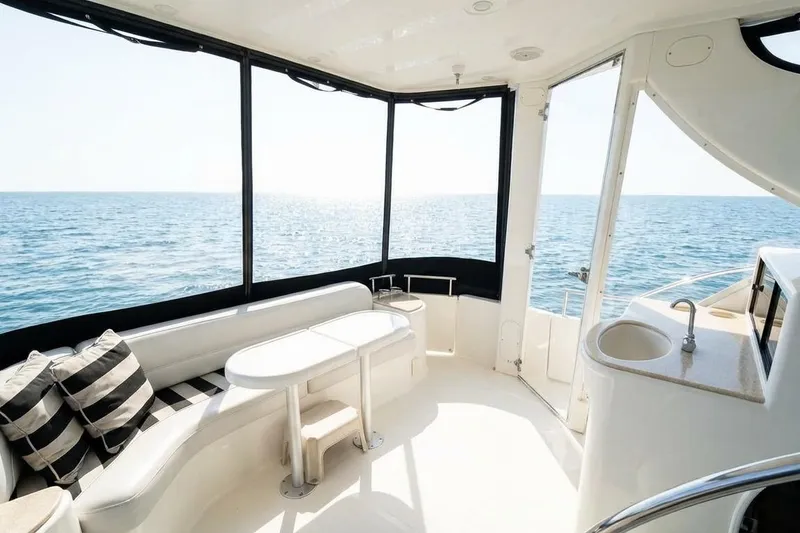 Slide: The Image of Luxurious 2005 Meridian 459 Motoryacht interior with ocean view, featuring seating and kitchenette. - 10