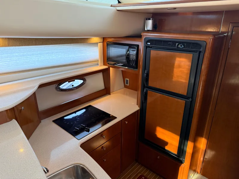 Slide: The Image of 2005 Meridian 459 Motoryacht kitchen with stove, microwave, and refrigerator. - 33