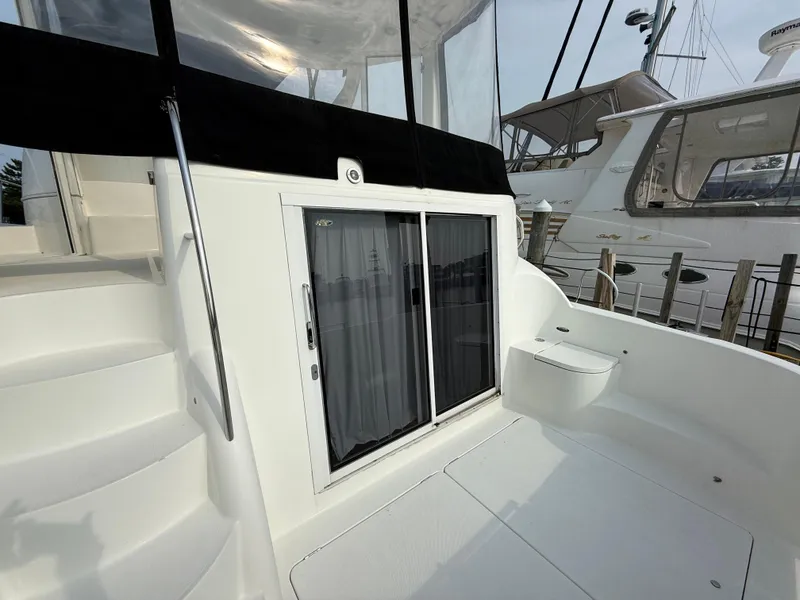 Slide: The Image of 2005 Meridian 459 Motoryacht deck with sliding glass doors and staircase. - 7