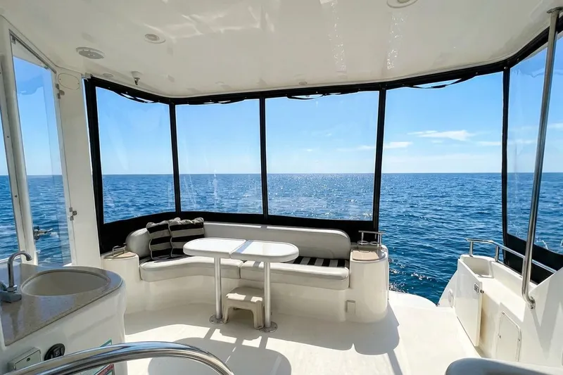 Slide: The Image of 2005 Meridian 459 Motoryacht interior with ocean view, featuring seating and table. - 9