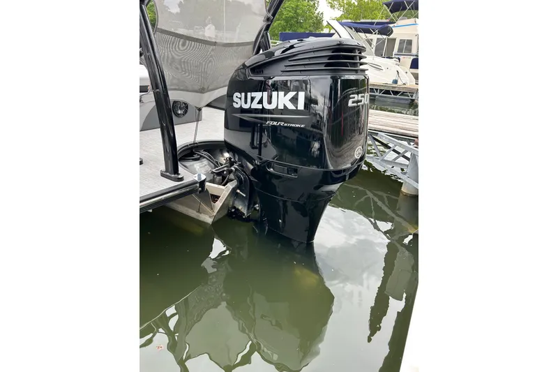 Slide: The Image of Outboard motor on a 2025 South Bay 525UL393 pontoon boat docked in water. - 12
