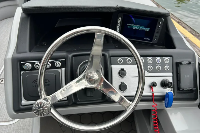 Slide: The Image of 2025 South Bay 525UL393 boat dashboard with steering wheel and marine electronics display. - 19