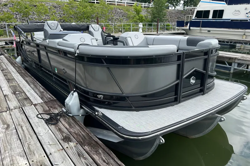 Slide: The Image of 2025 South Bay 525UL393 pontoon boat docked at marina, featuring sleek design and comfortable seating. - 2
