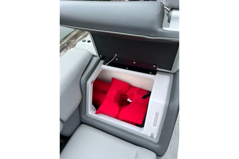 Slide: The Image of Storage compartment with red life jackets in a 2025 South Bay 525UL393 boat. - 39