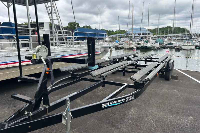 Slide: The Image of Boat trailer at marina, designed for 2025 South Bay 525 Tritoon, with sailboats in background. - 53