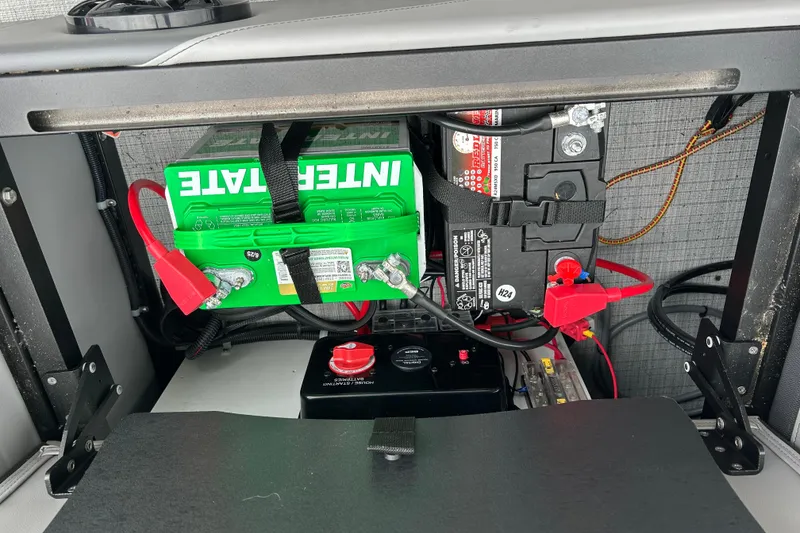 Slide: The Image of Battery compartment of 2025 South Bay 525UL393, featuring Interstate battery and wiring setup. - 44