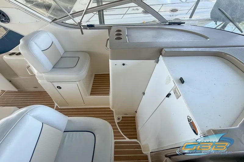 Slide: The Image of 2002 Bayliner 3055 Ciera cockpit with white seating and wooden flooring. - 12