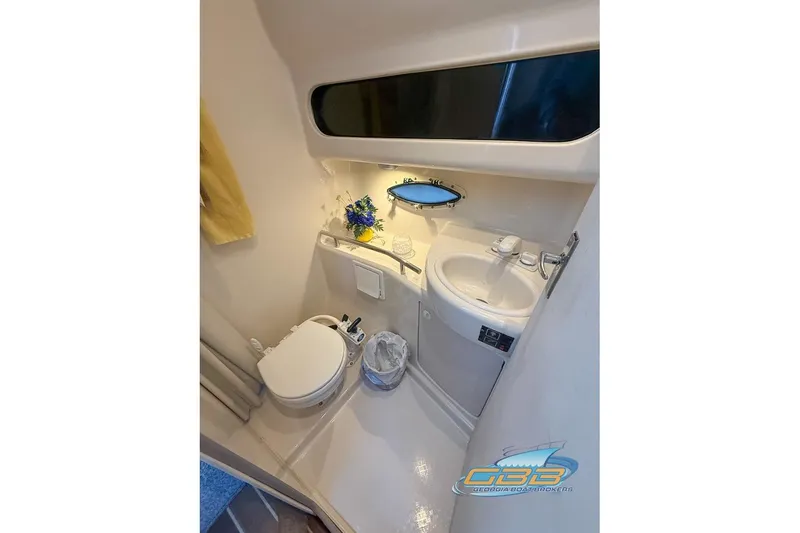 Slide: The Image of 2002 Bayliner 3055 Ciera bathroom with toilet, sink, and small window. - 15