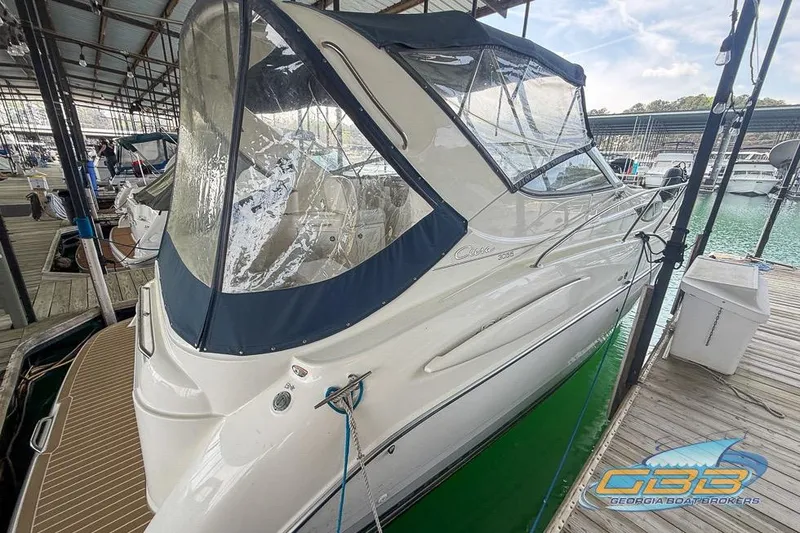 Slide: The Image of 2002 Bayliner 3055 Ciera docked in a marina, featuring a blue canopy and sleek design. - 17